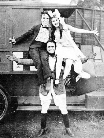 Publicity photo featuring Douglas Fairbanks supporting Charlie Chaplin and Mary Pickford, ca. 1919.